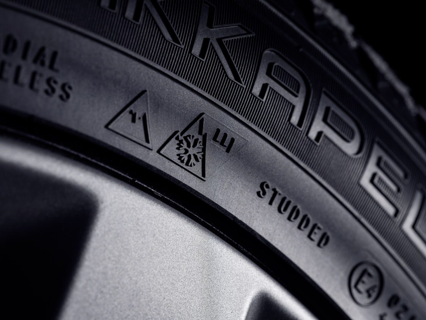 Reifenflanke mit Alpine-Symbol, Eisgriff-Kennzeichnung und dem Aufdruck STUDDED